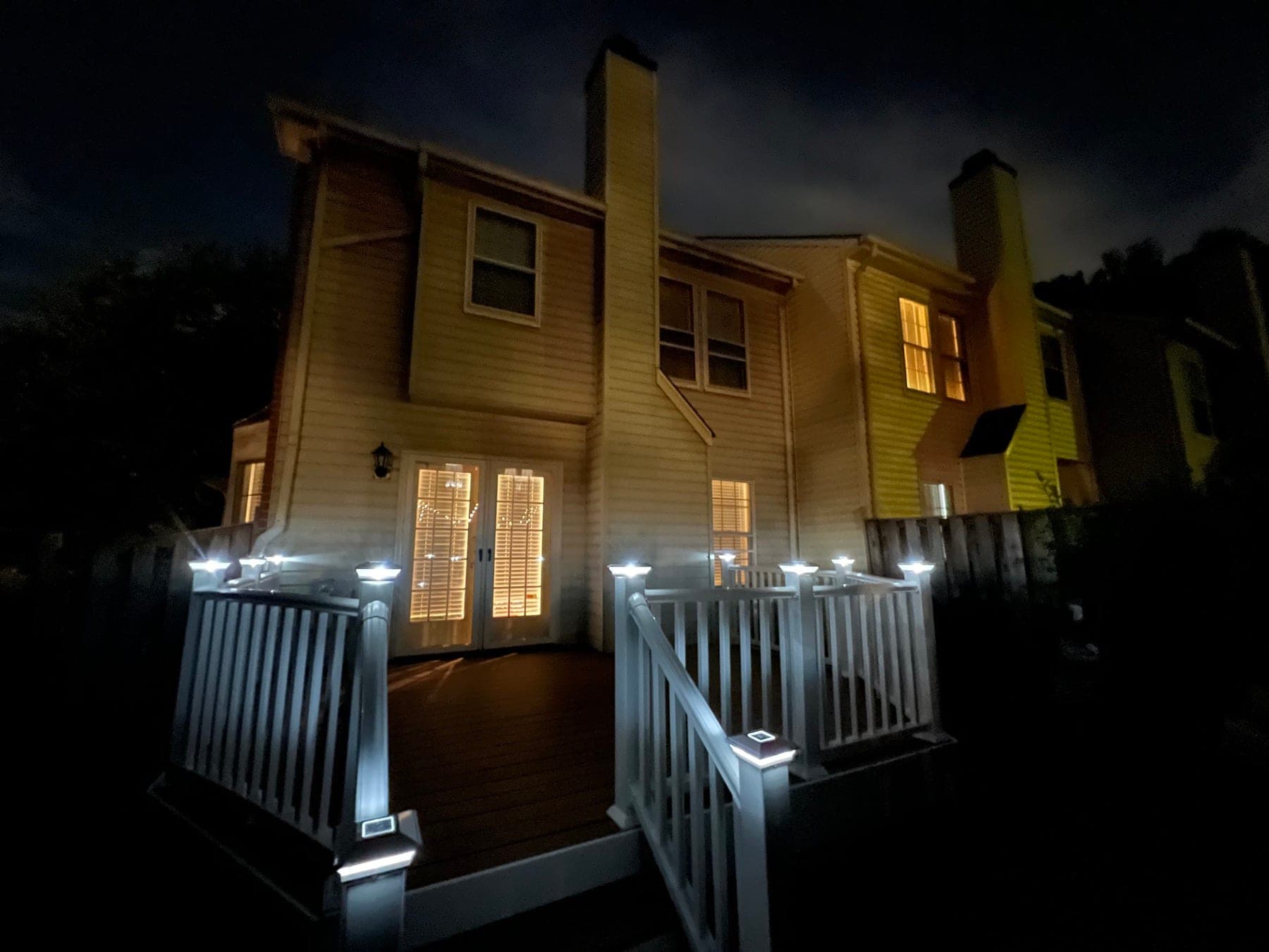 Finished composite deck with solar post lights at night